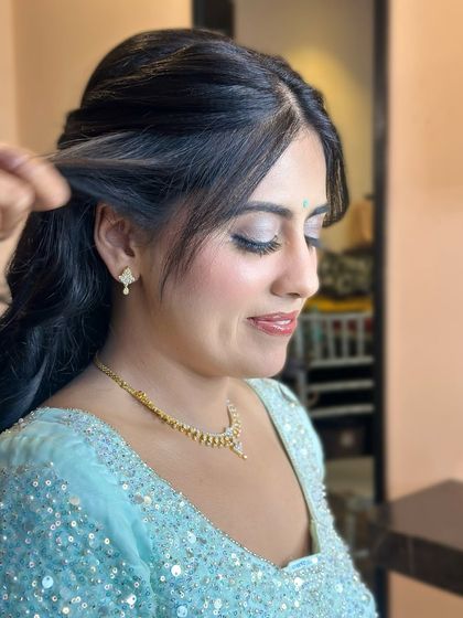 A behind-the-scenes shot of the hairstyling, with the makeup looking soft and shimmery.