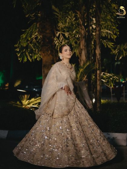A full-length shot of the bride, where the classic bun completes her regal wedding look.