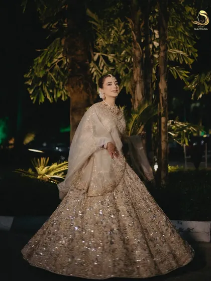 A full-length shot of the bride, where the classic bun completes her regal wedding look.