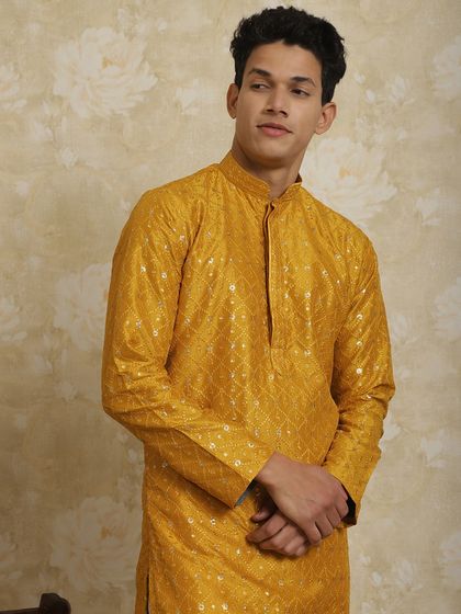A close-up of the mustard yellow kurta, showing the fine fabric and perfect fit.