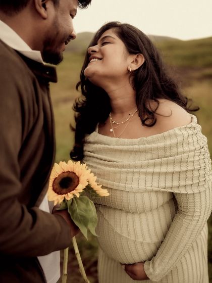 A beautiful close-up filled with joy. He presents her with a sunflower, and her laughing expression is pure, genuine happiness. It's these unscripted moments I love to capture.
