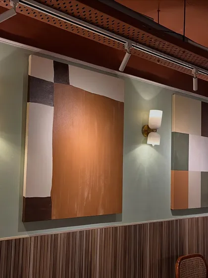 A wider view of the wall at Sidewalk, Kanpur, showing a large abstract piece next to the color block painting.