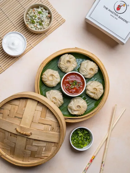 Our round steamed momos, filled with a savory vegetable mixture and served with our signature spicy dipping sauce. The bamboo steamer keeps them hot and moist until they reach your table.