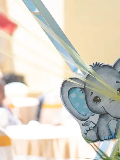 A cute baby elephant cutout, part of the decor for an elephant-themed birthday party. These small props add character to the setup.