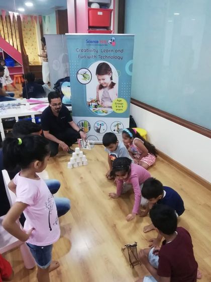 Kids on the floor, fully engaged in a building challenge. Our learning spaces are designed to be flexible and encourage hands-on interaction.