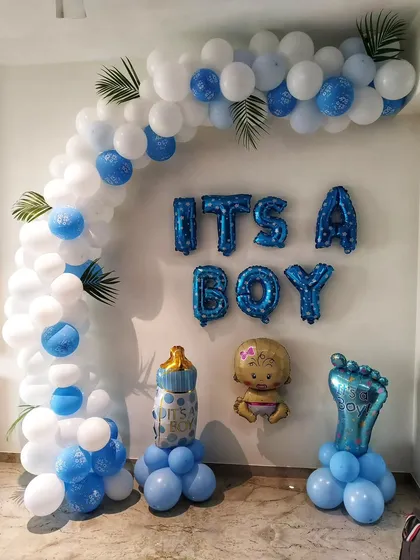 An 'It's a Boy' welcome setup with a blue and white balloon arch, foil letters, and baby-themed foil balloon props.