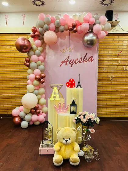 A full view of the Paris and teddy bear themed birthday decoration. This static image clearly shows all the elements, from the balloon arch and backdrop to the carefully placed props on the floor.