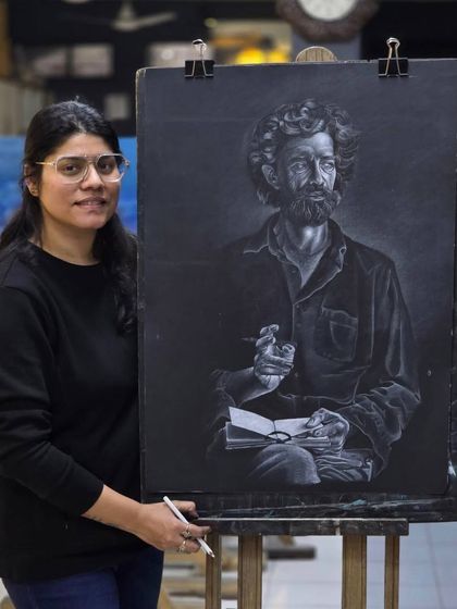 The artist proudly stands with her completed portrait, a powerful piece that demonstrates her mastery of the glass marking pencil technique.
