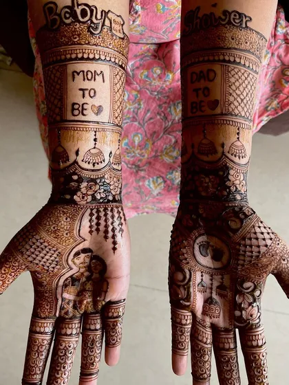 A beautiful example of a full baby shower design featuring a couple portrait on one palm. The other hand is decorated with baby themed symbols, and the forearms carry the proud announcement of "Mom to Be" and "Dad to Be".