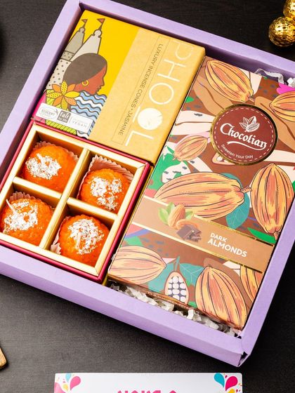 This gift box is a feast for the senses, featuring a box of motichoor ladoos, dark almond chocolates, and jasmine-scented luxury incense cones from Phool. It's a modern take on the classic festive gift.