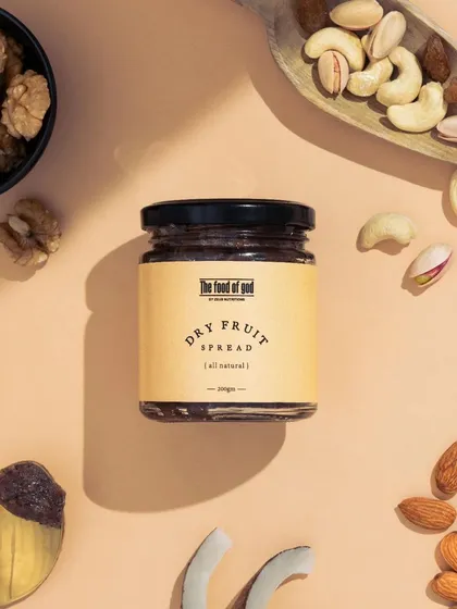 A top down flatlay showcasing all the natural ingredients that go into this dry fruit spread. This type of deconstructed shot is a great way to communicate the product's quality and contents in a visually appealing manner.