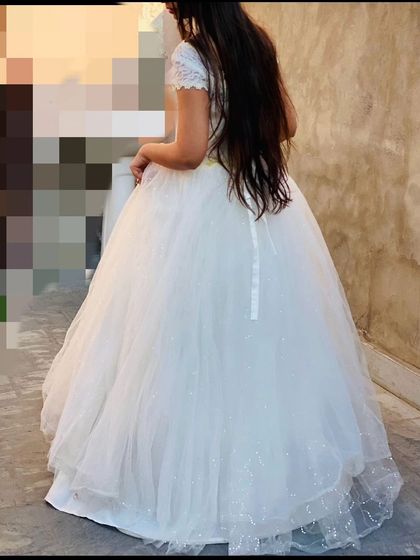 A back view of a classic white ball gown, showing the full tulle skirt. This type of dress is a timeless rental for pre-wedding photos.