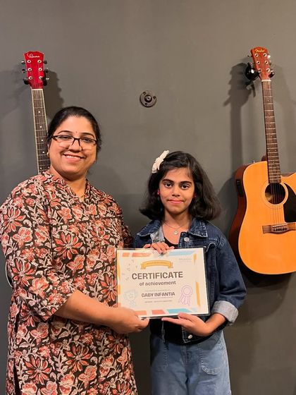 Young artist Gaby Infantia receives her certificate of achievement. We are proud to see our students excel in their musical endeavors.