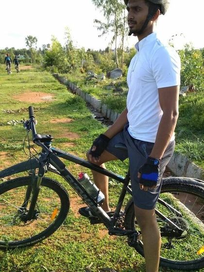 A rider and his mountain bike, ready for the trail ahead. The green surroundings are typical of our scenic off-road routes.