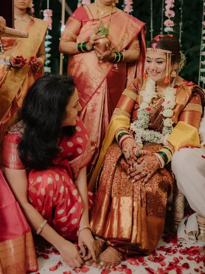 A touching moment between the bride and a family member during a wedding ritual. These inter-family connections are a beautiful part of any wedding story.