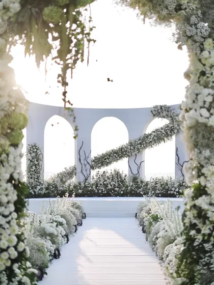 I believe wedding decor should be an ethereal experience. This all-white wedding ceremony set in Goa features clean architectural lines softened by a cascade of white florals, creating a breathtaking aisle that feels like walking through the clouds.