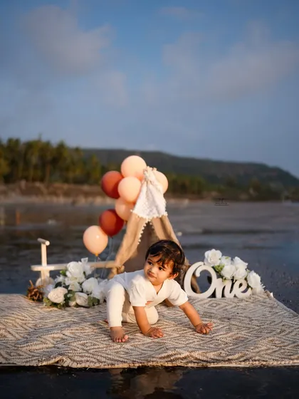 Capturing a moment of exploration as the birthday boy crawls across the mat. This shot highlights his natural curiosity within the beautifully styled beach setup.