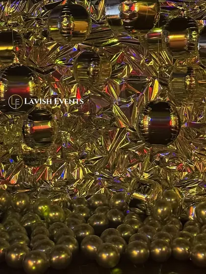 The same metallic photobooth under gold lighting, showing its versatility.