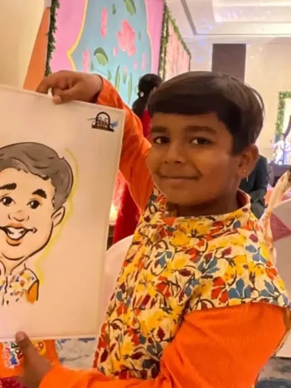 A young boy in a colorful vest holds up his caricature, a perfect match for his bright and cheerful personality.