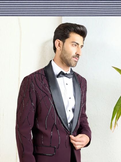 Another artistic presentation of the wine-colored tuxedo, emphasizing its sophisticated lines and the intricate pattern of the beadwork.