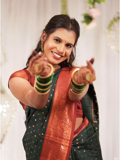 The bride makes a heart sign with her hands, a fun and expressive candid shot.