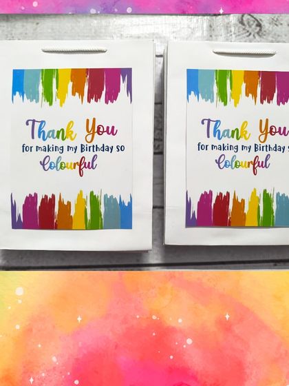 The matching rainbow-themed paper bags, which thank guests for making the birthday "so colourful."