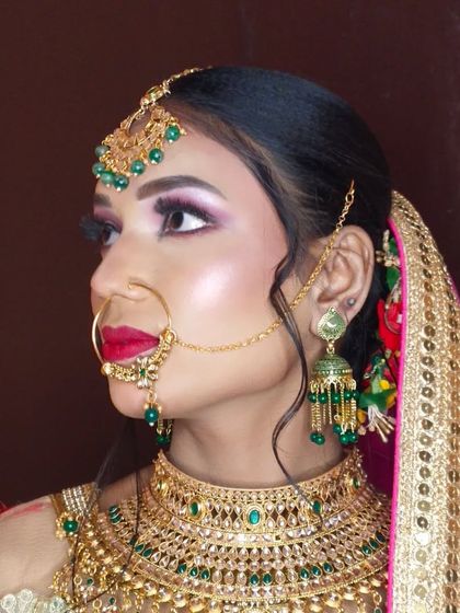 A side profile showing the flawless base and how the makeup complements her green and gold jewellery.