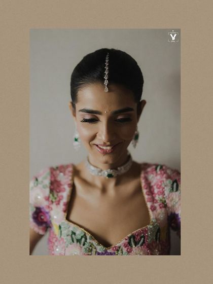 A beautiful close-up portrait of the bride, her smile radiating happiness. The simple diamond maang tikka and her natural expression create a look of modern elegance.