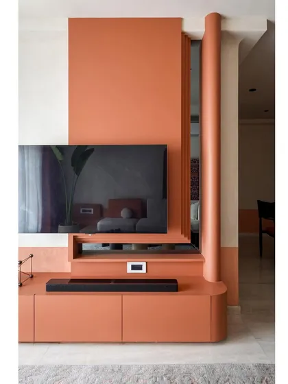 The TV unit, with its clean lines and warm terracotta color, is a perfect example of modern design with a touch of South Indian warmth.