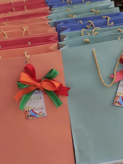 The colorful gift bags for the Holi Aqua Adventure party, each with a custom tag and a multi-colored ribbon.