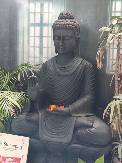 The intricate details of the hair and robes on this 4-foot black marble Buddha are a result of hours of meticulous hand carving. This large Buddha statue is a masterpiece of spiritual art.