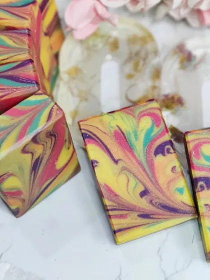 A close-up of a vibrant peacock swirl soap. The shimmering micas I use catch the light beautifully, making the colors look even more rich and complex.