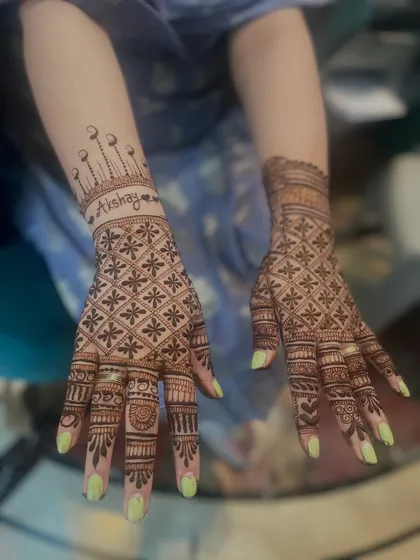 A modern take on personalization, with the groom's name 'Akshay' written in a stylish font, crowned with a beautiful design. This is paired with a full hand of intricate jaali work.