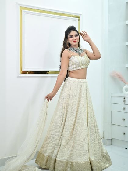 A playful pose in the ivory and gold lehenga, showing its beautiful movement. The dark gemstone necklace adds a touch of modern elegance.