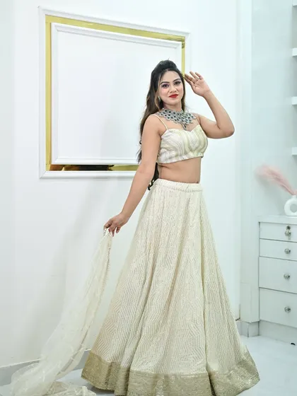 A model posing in the ivory chikankari lehenga, paired with a stunning modern diamond necklace.