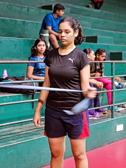 A player uses a resistance band for a shoulder strengthening exercise, crucial for preventing injuries and increasing shot power.