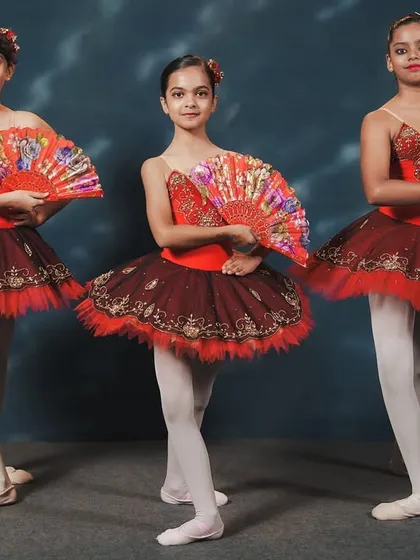 Dancers from our 'Don Quixote' performance. The use of fans as props adds a fiery, Spanish-inspired flair to the classic ballet choreography, showcasing both technique and personality.