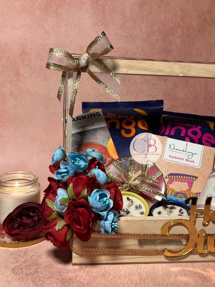 Light up hearts this Diwali with our thoughtfully curated hampers. This pinewood basket is filled with healthy snacks, a handmade candle, and our special mithai-shaped chocolates.