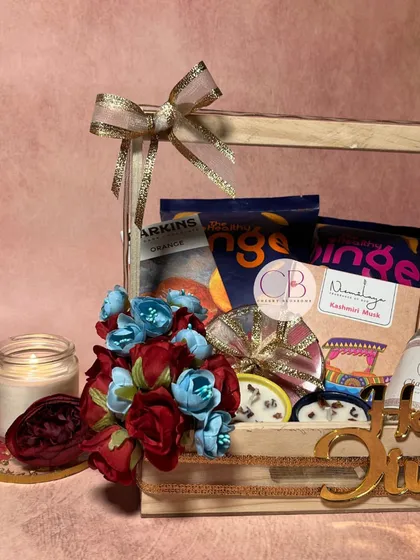 Light up hearts this Diwali with our thoughtfully curated hampers. This pinewood basket is filled with healthy snacks, a handmade candle, and our special mithai-shaped chocolates.