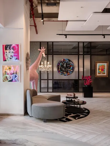 Spotted in our gallery: Neon confessions and a giraffe holding a chandelier. The Designera isn’t just an art gallery; it’s a full-blown mood.