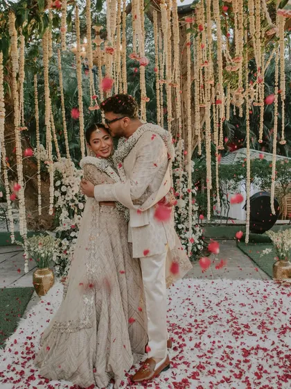 A hug filled with love and emotion right after the Varmala ceremony. The falling petals add a touch of magic to this heartfelt moment.