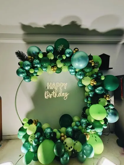 A clear, well-lit photo of the stunning green and gold birthday setup.