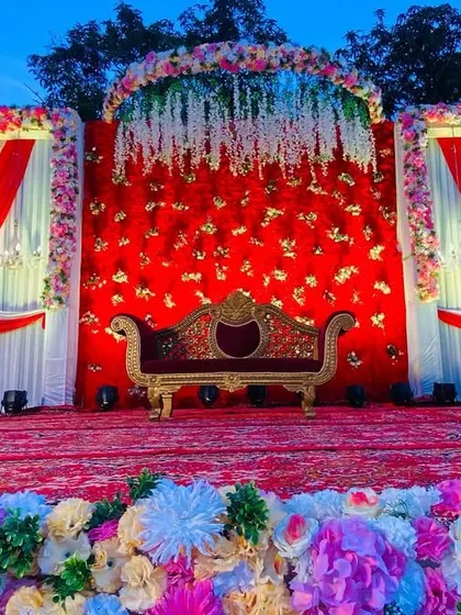 A full view of the red and white draped stage, showing the beautiful floral border and the overall grand setup.