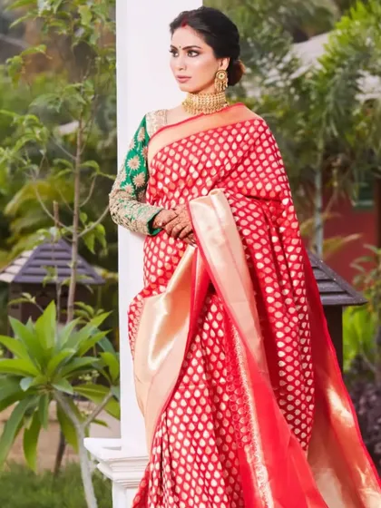 The elegance of a traditional saree for a reception. The bride looks absolutely regal in her red Banarasi saree, with her bold eye makeup and classic updo creating a sophisticated and timeless look.