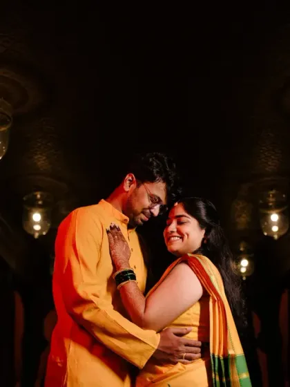 An intimate, low-light portrait of the couple, their faces close together, showcasing the romance and emotion of their wedding day.