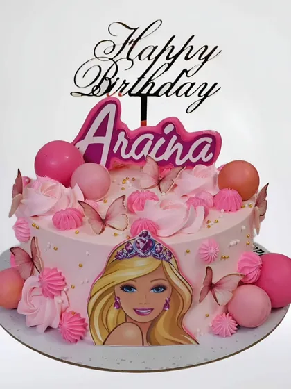 A pretty pink Barbie-themed cake perfect for a birthday girl. This simple yet elegant whipped cream cake is decorated with pink spheres, butterflies, and a classic Barbie portrait.