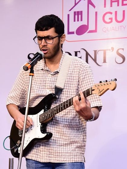 An adult student rocks the stage with his electric guitar. Our concerts feature a wide variety of genres, from acoustic pop to rock music.