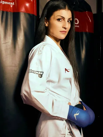 Ready for combat. A student equipped with sparring gloves stands by a punching bag, illustrating our focus on practical application and modern training methods like kickboxing.