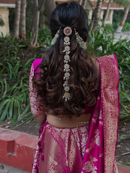 A beautiful half-up style with soft curls, accented by a traditional, cascading hair ornament. This is a great way to blend modern waves with traditional jewelry.