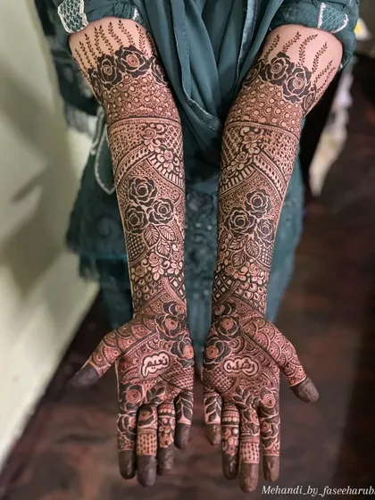 A clear, full view of the intricate bridal henna, showing how the patterns flow from the palm to the forearm.